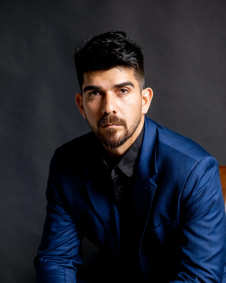 Dr. Ronaldo Morari sentado, de terno azul